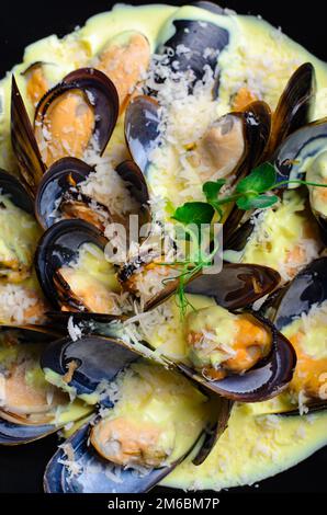 Freshly cooked mussles in wine and creamy sauce in a plate on a table Stock Photo