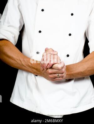 Professional chef with a hand gesture towards, wearing a chefs jacket Stock Photo