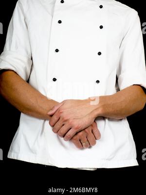 Professional chef with a hand gesture towards, wearing a chefs jacket Stock Photo