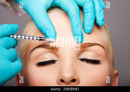 Cosmetic plastic surgeon injecting aesthetics face Stock Photo