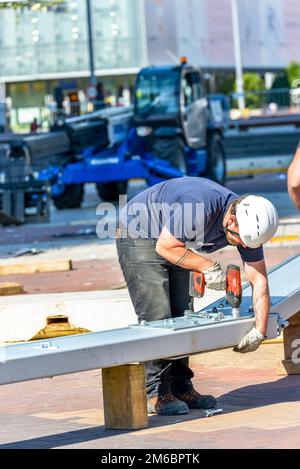 La defense, France- April 10, 2014: worker fastening a big bolt in a metal beam on a construction site Stock Photo