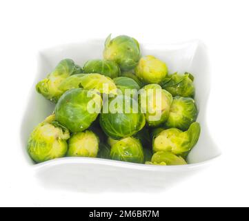 White designer bowl with fresh green brussel sprouts isolated on white Stock Photo