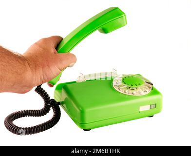 On a white background male hand holding a green telephone handset rotary dialer Stock Photo