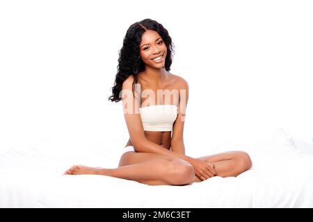 Beautiful happy woman sitting on bed Stock Photo
