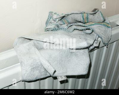 Two recently washed tea towels dried on a radiator in house Stock Photo