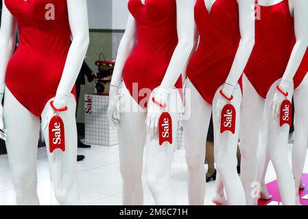 Series of mannequins in red swimsuits. Sale Stock Photo