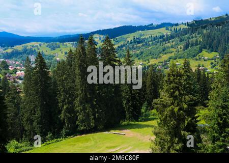 Summer view of Carpathian Mountains landscapevillage Vorohta Ukraine. Green forests, hills, grassy meadows and blue sky