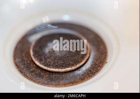 Selective focus on a closed bronze sink drain. Stock Photo