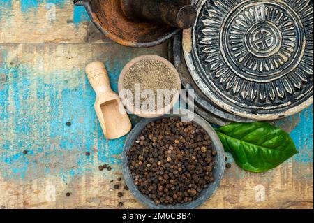 ndian spices collection, dried black peppercorns and another spices in clay bowls close up Stock Photo