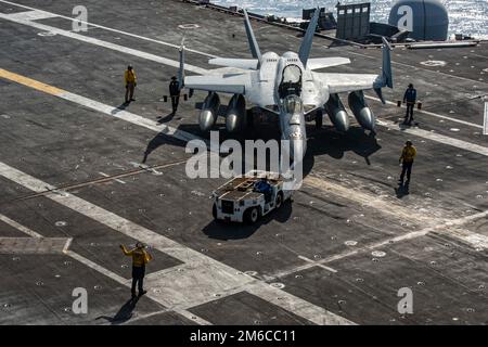 USS Nimitz, United States. 02 January, 2023. A U.S. Navy F/A-18E Super Hornet fighter aircraft from the Kestrels of Strike Fighter Squadron 146, dis towed across the flight deck of the Nimitz-class aircraft carrier USS Nimitz underway conducting routine operations, January 2, 2023 in the Philippine Sea.  Credit: MC3 Hannah Kantner/U.S Navy Photo/Alamy Live News Stock Photo