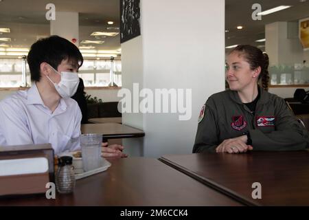 Yo Nonoyama, Ambassador’s Youth Council member, left, talks with Capt. Madeline Atkinson, 36th Airlift Squadron pilot, during a lunch meeting for the AYC at Yokota Air Base, Japan, April 22, 2022. Volunteers across from various squadrons across Yokota took the time to eat lunch with the AYC to give them an insight on what it is like to be a military member and how they support a larger mission. Stock Photo