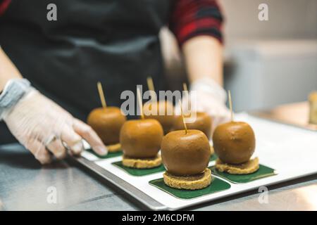 Pastries - making process. Closeup portrait of apples covered in caramel getting reading for decorating. High quality photo Stock Photo