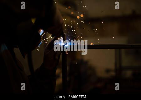 Metal welding. Sparks in dark. Welder's job. Stock Photo