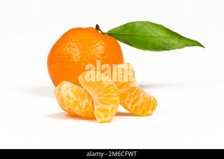 Three slices of a mandarin close-up against a whole mandarin background Stock Photo