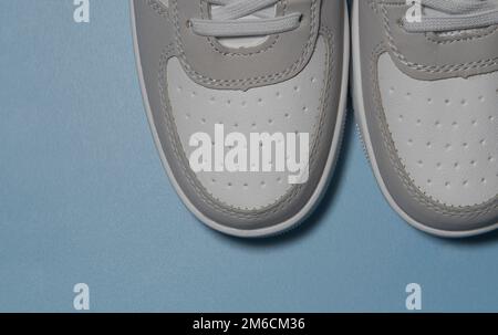 The texture of the stitching of leather white sneakers. Close-up. On a blue background Stock Photo