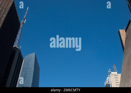 Balloons and helicopter in the blue sky of the metropolis. Stock Photo