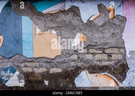 Distressed graffiti painted on a brick concrete wall. Stock Photo