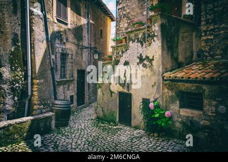 Colorful flowers on a worn alley of a medieval town. Stock Photo