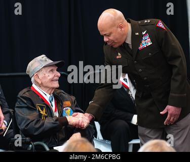 Former U.S. Army Air Corps Sgt. Arthur Kemp, 98, of Logan County, Ohio, is congratulated by Maj. Gen. John C. Harris Jr., Ohio adjutant general, after his induction into the Ohio Military Hall of Fame April 22, 2022, at the Ohio Statehouse Atrium in Columbus, Ohio. Kemp was awarded the Distinguished Flying Cross in July 1944 while serving as a B-17 tail gunner assigned to the 508th Bomb Squadron, 351st Bomb Group during World War II. The OMHOF recognizes Ohio veterans who were awarded medals for valor during their military service. Stock Photo