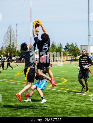 Participants from Team Misawa play flag football during the first-ever Sakura Olympics at Misawa Air Base, Japan, April 22, 2022. The Sakura Olympics gets its name from the famous cherry blossom tree. Throughout history, the Japanese government has given numerous cherry blossom trees to the U.S. government, symbolizing the bond between the two nations. Stock Photo