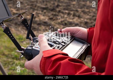 Man operating of flying drone. Drone remote control in man hands. Stock Photo
