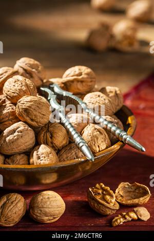 still life with walnuts in a wooden bowl on a table Stock Photo