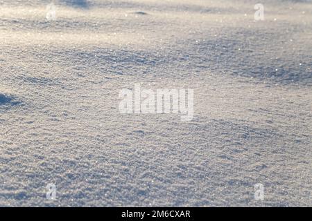 Background of white snow sparkling in the sun. Shallow depth of field Stock Photo