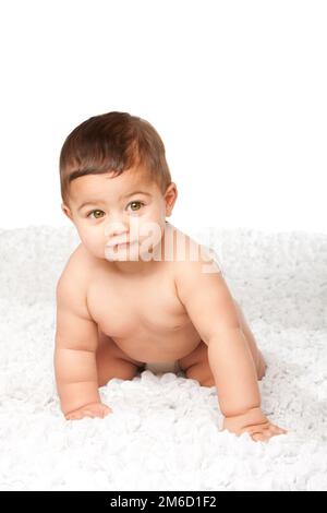 Cute baby infant with big green eyes crawling on white Stock Photo