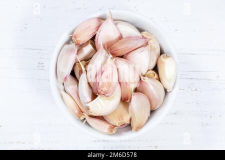 Garlic cloves from above bowl wooden board Stock Photo