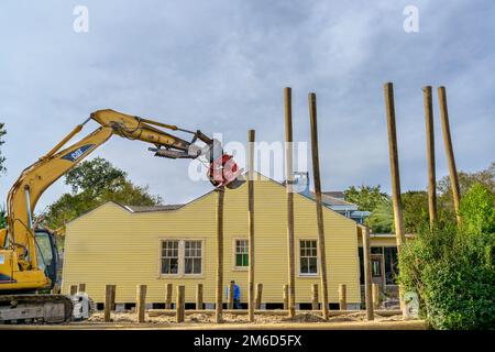 NEW ORLEANS, LA, USA - OCTOBER 18, 2022: Full side view of pile driver at work on residential construction site in Uptown neighborhood Stock Photo