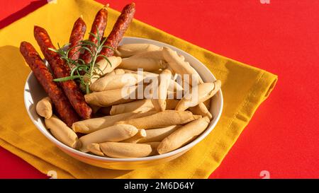 Spanish mini chorizo and picos on yellow Stock Photo