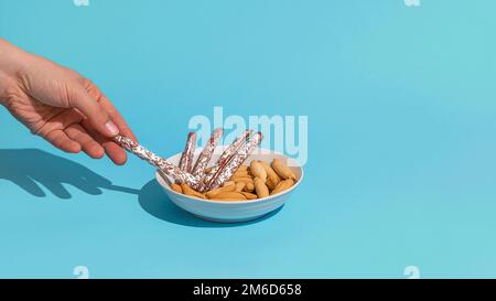 Womans hand take mini fuet from bowl Stock Photo
