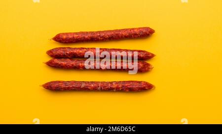 Flat lay of Spanish mini chorizo on yellow Stock Photo