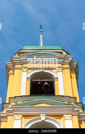 Yellow Orthodox Christian church with a green dome in summer against a blue sky with white clouds. Stock Photo
