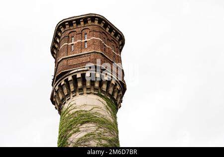 A close look at an old abandoned brick and concrete water tower overgrown with ivy. Sofia, Bulgaria. Stock Photo