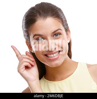 Ive got it. Studio shot of a beautiful young woman pointing towards something against a white background. Stock Photo