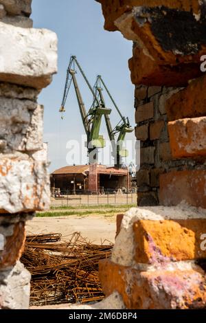 Gdansk, Poland - July 19 2022: Industrial building at the Gdansk Shipyard, former Lenin Shipyard, prefabrication workshop and heavy cranes large Polish shipyard. Cranes at historical shipyard in Gdansk headquarters of Solidarity Polska Stock Photo