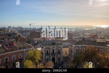 Catania medieval city center, with Sant'Agata cathedral and medieval town rooftops, and modern port terminal in the Mediterranean sea, Sicily, Italy, Stock Photo