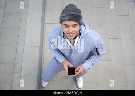 Smiling young latin man runner winter sports training from above Stock Photo
