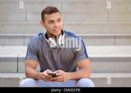 Smartphone cell phone listening to music young latin man looking up listen Stock Photo