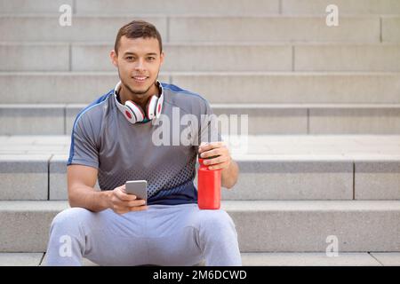 Smiling young latin man runner jogger sport sports smartphone copyspace copy space Stock Photo