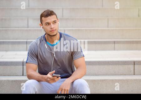 Listening to music young latin man looking up smartphone listen copyspace copy space Stock Photo