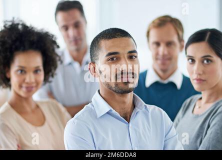 Working together towards success. Portrait of a group of diverse colleagues standing in an office. Stock Photo