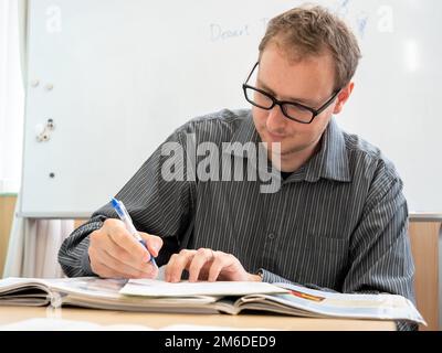 A man writing up paperwork at work. Stock Photo