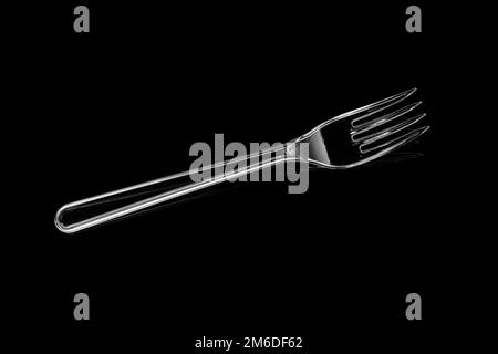 Transparent plastic fork isolated on black background Stock Photo