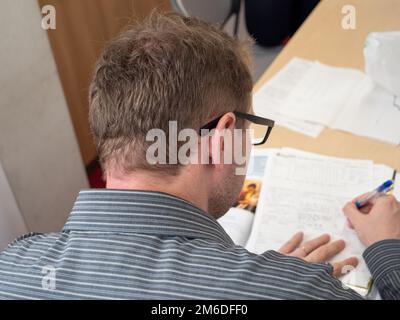 A man writing up paperwork at work. Stock Photo