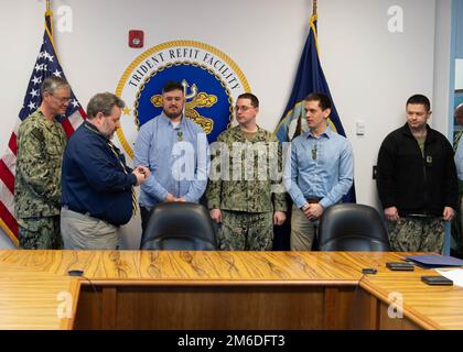 SILVERDALE, Wash. (Apr. 25, 2022) –Christopher McNeil (second from left), SUBSAFE director at Trident Refit Facility, Bangor (TRFB), presents the 2021 USS Thresher Memorial Award recipients each with a USS Thresher Memorial coin. The annual USS Thresher Memorial Award recognizes individuals whose contribution most positively influenced the culture, processes, and execution of the SUBSAFE program at TRFB. Stock Photo