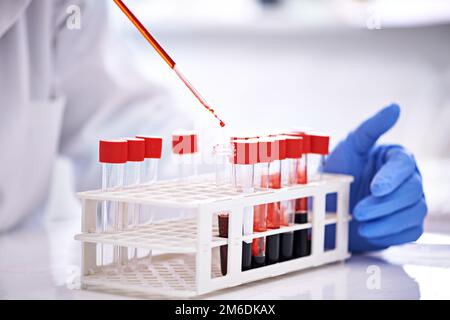 Examining one sample at a time. a scientist working with blood samples in the lab. Stock Photo