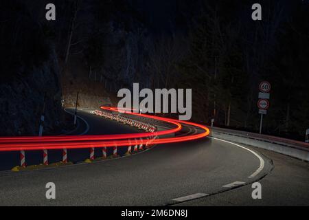 Light trails of car on curvy street at night Stock Photo
