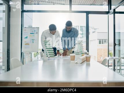Planning, building model and architecture team analyzing a construction blueprint in an office. Teamwork, collaboration and industrial workers working Stock Photo